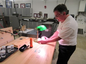 Bruce Hart, manager of Saginaw Valley State University's Independent Testing Lab, shows new epoxy samples from Gougeon Brothers Inc. in Bay City that are intended for use on surfboards.